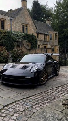 a black sports car parked in front of a house