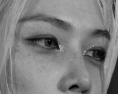 black and white photograph of a woman's face with glitter on her eyeliners