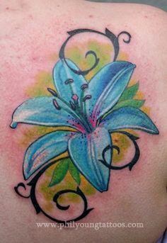 a blue flower tattoo on the back of a woman's shoulder