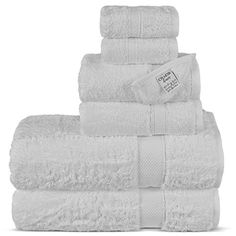 white towels stacked on top of each other in a pile, with the tag hanging off