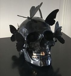 a skull with two butterflies on it's head sitting on top of a table