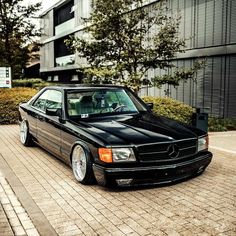 a black mercedes benz parked in front of a building