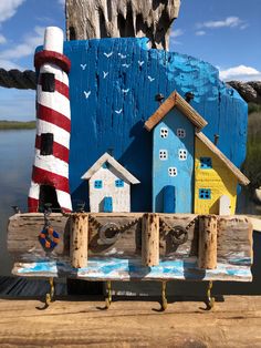 a wooden boat with houses and a lighthouse on the front is painted blue, white, and red