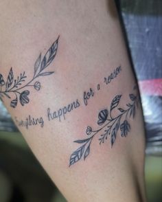 a tattoo saying nothing happens for a reason on someone's leg with leaves around it