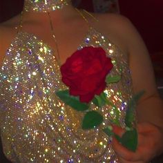 a woman in a sequin dress holding a rose