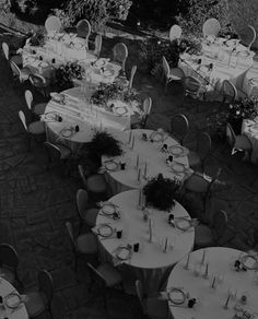 an aerial view of tables and chairs set up for a formal dinner in black and white