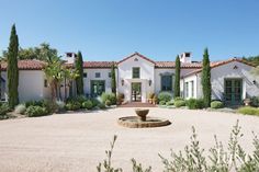 a large white house with a fountain in the front yard