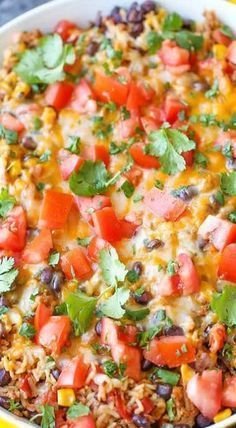 mexican rice casserole with black beans, tomatoes and cilantro in a yellow dish