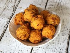 a white bowl filled with fried food on top of a wooden table