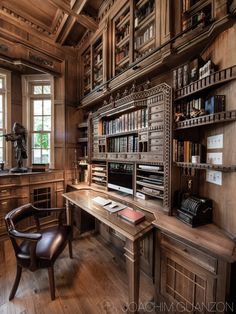 a wooden desk sitting in front of a window next to a book shelf filled with books