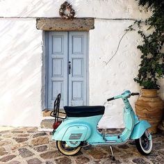 a blue scooter parked in front of a white building