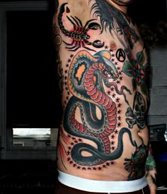 a man with a dragon tattoo on his back and chest is posing for the camera