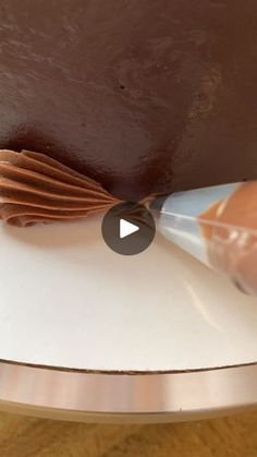 someone is decorating a cake with chocolate icing