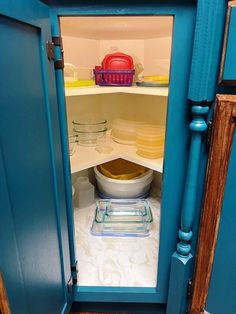 an open refrigerator door with plates and bowls in it