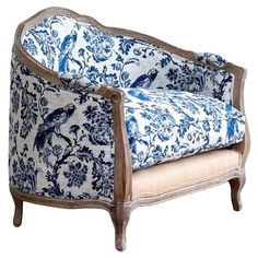 an ornate blue and white chair with birds on it's armrests, against a white background