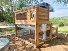 an outdoor chicken coop in the middle of a field