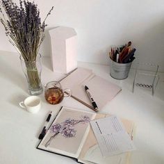 an open book sitting on top of a table next to a vase filled with flowers