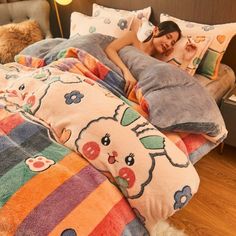 a woman laying in bed with pillows on top of her and an animal themed comforter