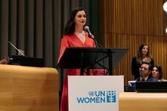 a woman standing at a podium in front of an audience