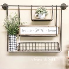 two metal shelves with plants and coffee mugs on them, hanging from the wall