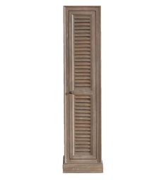 a tall wooden door with shutters on the side and bottom panel, in front of a