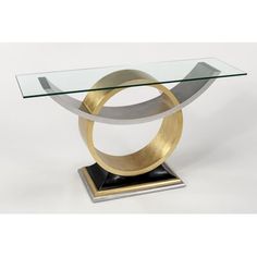 a glass and metal table with a circular design on the top, in front of a white background