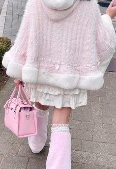 a woman walking down the street wearing pink boots and a fluffy coat with white fur