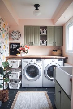 a washer and dryer in a small room next to a counter with flowers on it