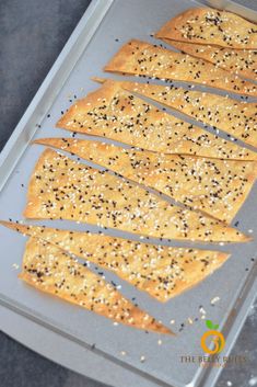 bread sticks with sesame seeds and seasoning on a baking sheet, ready to go into the oven