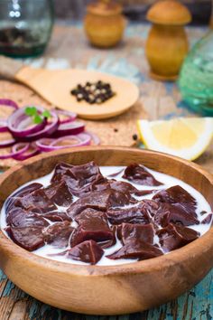 a wooden bowl filled with pudding next to sliced onions