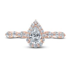 a rose gold engagement ring with an oval cut diamond center and pave set shoulders