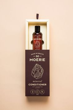 a bottle of mcorerie mineral conditioner sitting in a box on a wall