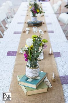 a long table with flowers and books on it