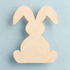 a wooden cutout of a rabbit on a blue background