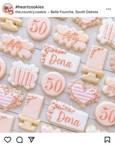 cookies decorated with pink and white icing are displayed on a table