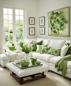 a living room filled with white furniture and green pillows on top of it's couches