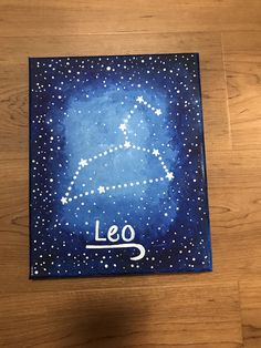 the leo zodiac sign painted on a wooden surface with white stars in the night sky