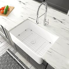 a white kitchen sink sitting on top of a counter next to a cutting board and vegetables