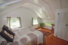 a bedroom with white walls and wooden floors