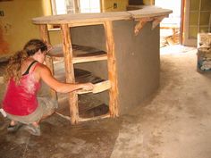 a woman kneeling down in front of an oven