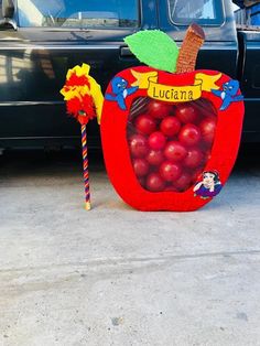 there is an apple shaped candy bar in front of a car that says luciata