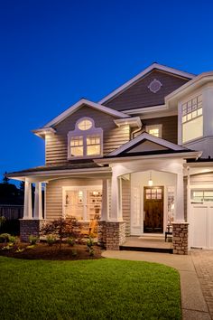 a house that is lit up at night with lights on the front and side windows