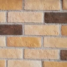 a brick wall with brown and tan bricks