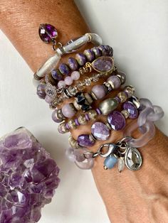 A stack of soft lavender and purple tones. All are sold separately but work well together so feel free to build you own mini stack. They are all stretch bracelets- strung on strong clear elastic, except for 2 (#7 and #8). Here are the details: Bracelet 1: Czech glass tube beads with an AB finishes. Silver disc spacers, Czech glass faceted heart charm with AB finish. Bracelet 2: Czech Picasso rondelle beads, dusty purple with tan/green accents on the sides Bracelet 3: 6 mm faceted light amethyst Large Bead Bracelet, Brand Deck, Soft Lavender, Purple Tones, Gems Bracelet, Light Amethyst, Silver Flats, Dusty Purple, Boho Bracelet