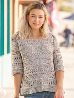 a woman is walking down the street with her hand in her pocket