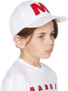 Gabardine cap in white featuring logo graphic embroidered in red at face. Logo embroidered in black at back face. · Curved brim · Embroidered eyelets at crown · Adjustable cinch strap at back face · Partially lined · Hand wash Supplier color: White Marni Size: Recommended Age 1: 3-6M 2: 9-12M 3: 18-24M White Flat Brim Baseball Cap With Logo Patch, White Hat With Letter Patch For Streetwear, White Letter Patch Hat For Streetwear, White Streetwear Hat With Letter Patch, White Snapback Hat With Letter Patch, White Cotton Baseball Cap With Letter Patch, White Baseball Cap With Letter Patch, White Visor Hat With Logo Patch, White Adjustable Snapback Hat With Letter Patch