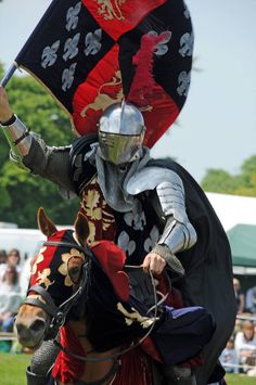 a man in armor riding on the back of a horse holding an umbrella over his head