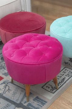 three different colored stools sitting on top of a rug