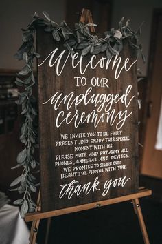 a wooden sign that says welcome to our engaged ceremony with greenery on it and the words, thank you