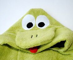 a green frog towel with eyes and tongue sticking out